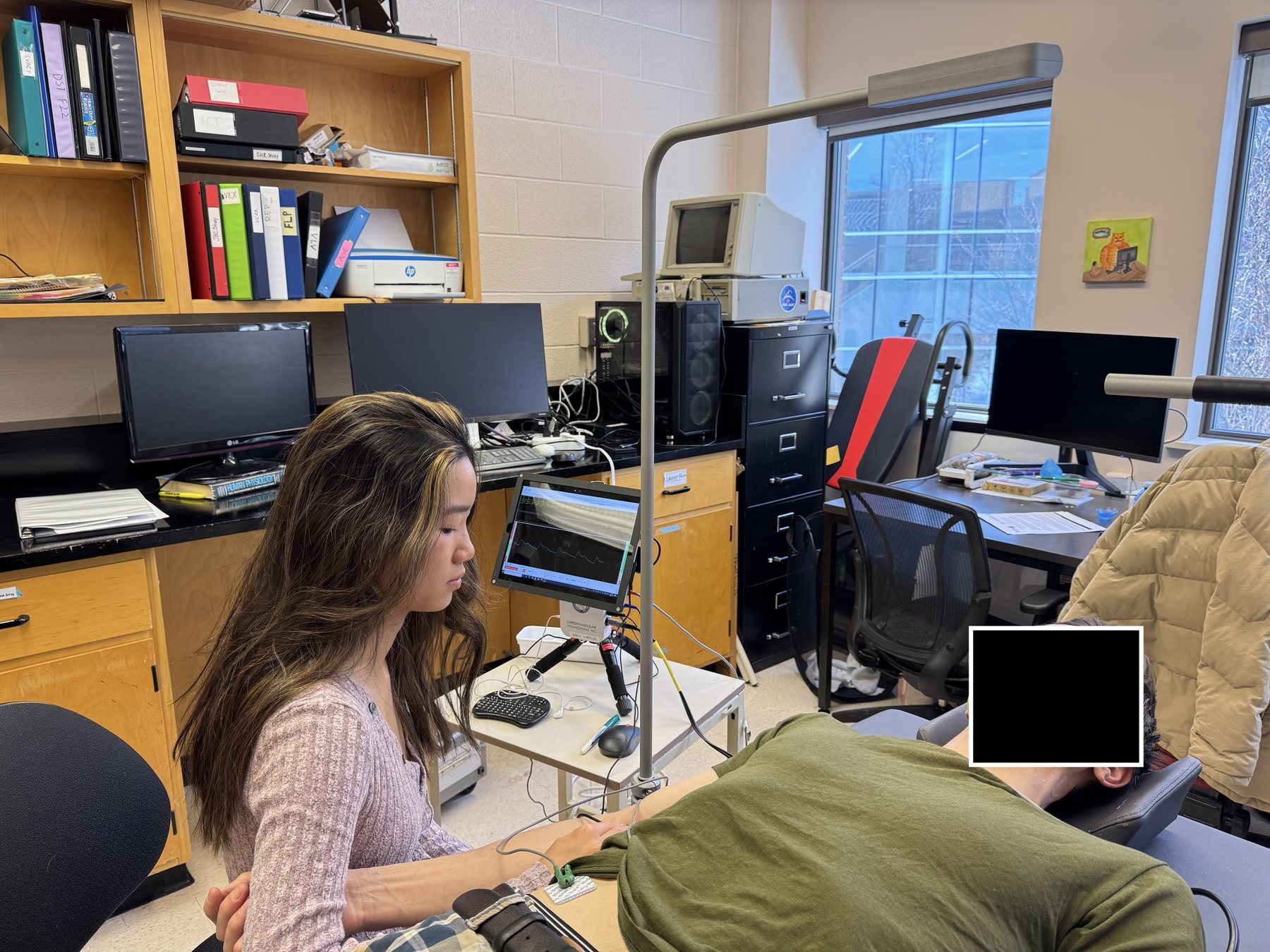 Performing an applanation tonometry assessment on a study participant (participant's face blocked for privacy)