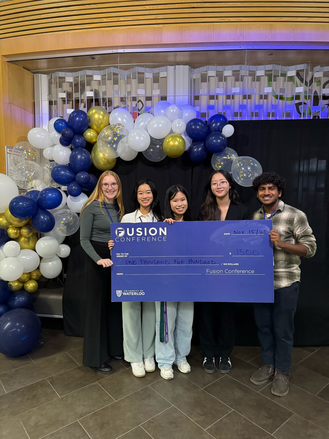 Holding a $1,500 award check at the Fusion Conference, University of Waterloo