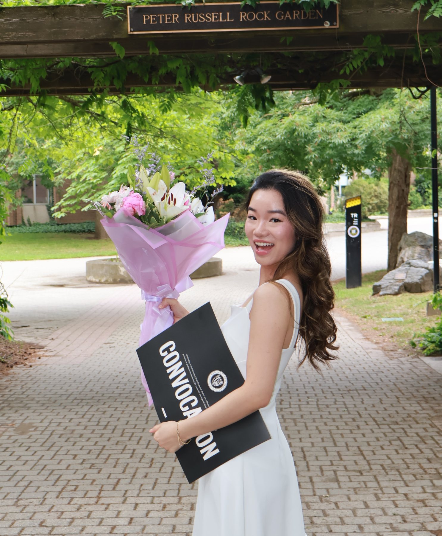 University of Waterloo convocation, holding flowers and a diploma folder
